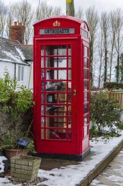 2 Şubat 2019 Tremeirchion, İngiltere'de. Geleneksel İngiliz telefon kulübesi bir turistik ve topluluk bilgi standında olarak repurposed.