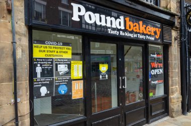 Chester, UK: 14 Haziran 2020: Sosyal uzaklık talimatları Poundbakery 'nin Chester şubesinde açıkça gösteriliyor.