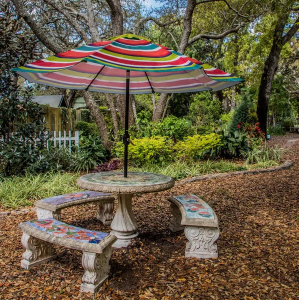 Umbrella and table in the garden — Stock Photo, Image