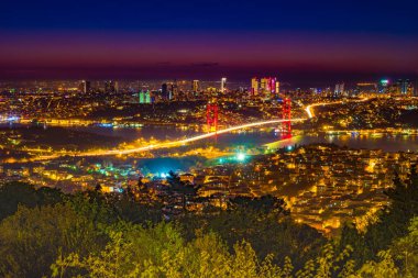 İstanbul Boğazı Köprüsü, gece. 15 Temmuz Şehitler Köprüsü. Camlica Hill 'den gece görüşü. İstanbul, Türkiye.