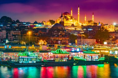 Süleymaniye Cami, gece görünümüne Galata Köprüsü, Istanbul, Türkiye. Renkli gemi ve altın boynuz su yansıması olan güzel gece görünümü