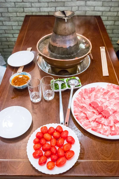 Una olla china tradicional con carne y condimentos . —  Fotos de Stock