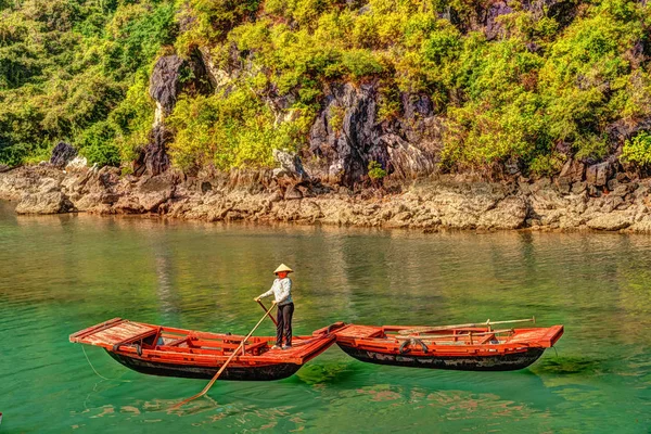 Unerkennbare vietnamesische Ruderboote, die im Sommer Touristen in die Kalksteinhöhle mit der Kalksteininsel im Hintergrund in die Halong-Bucht bringen. Vietnam. — Stockfoto