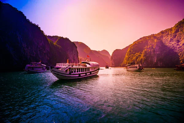 Puesta de sol en Halong Bay Vietnam con barcos turísticos en primer plano —  Fotos de Stock