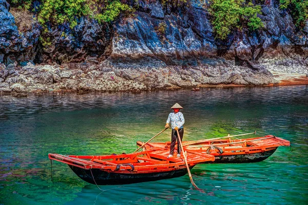 Mujeres vietnamitas irreconocibles botes de remos que traen turistas que viajan dentro de la cueva de piedra caliza con la isla de piedra caliza en el fondo en verano en la bahía de Halong. Vietnam . — Foto de Stock