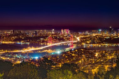 Istanbul Boğaziçi Köprüsü güzel aydınlatmalı gün batımında. Çamlıca Tepesi'nden gece görünümü. Istanbul, Türkiye.