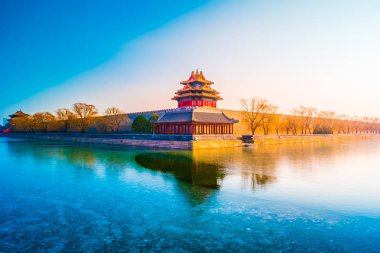 The wall and frozen moat of the Forbidden City at sunset. clipart