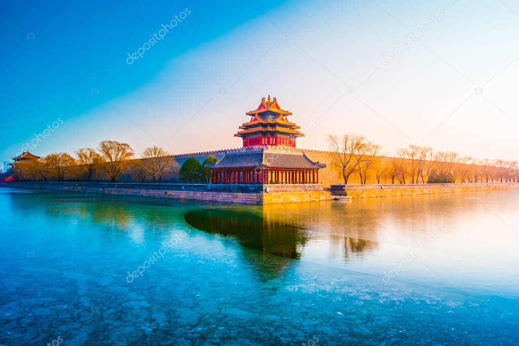 The wall and frozen moat of the Forbidden City at sunset.