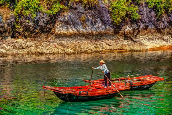 Mulher vietnamita irreconhecível remo barcos que trazem turistas que viajam dentro da caverna de calcário com ilha de calcário no fundo no verão em Halong Bay. Vietname . — Fotografia de Stock