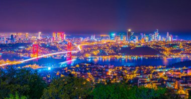 Istanbul Boğaziçi Köprüsü güzel aydınlatmalı gün batımında. Çamlıca Tepesi'nden gece görünümü. Istanbul, Türkiye.