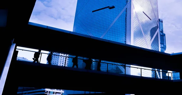 A group of people is against the backdrop of modern buildings. Blurred motion. — Stock Photo, Image