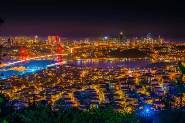 Istanbul Boğaziçi Köprüsü güzel aydınlatmalı gün batımında. Çamlıca Tepesi'nden gece görünümü. Istanbul, Türkiye.