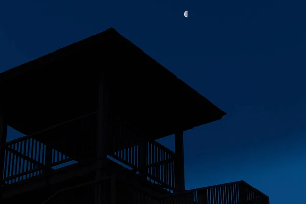 Silhouette of house with moon in the background