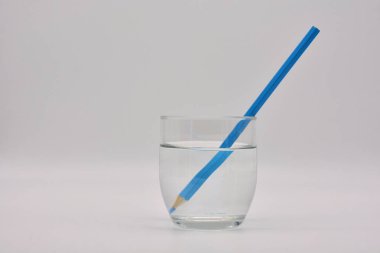 Refraccion de la luz, demostrada en un vaso de agua con lapices de colores