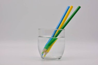 Refraccion de la luz, demostrada en un vaso de agua con lapices de colores