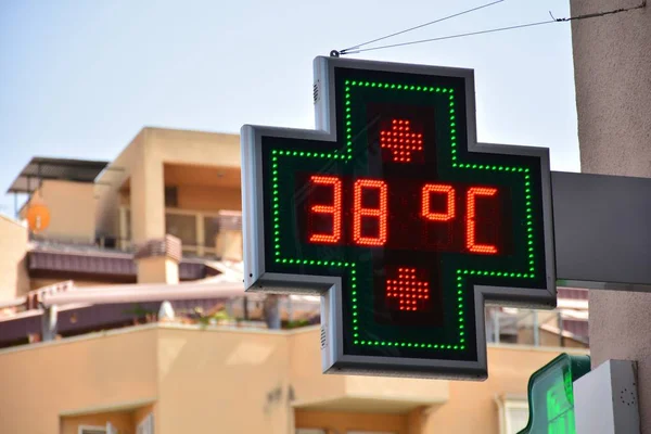 street thermometer of a pharmacy marking 38 degrees celsius