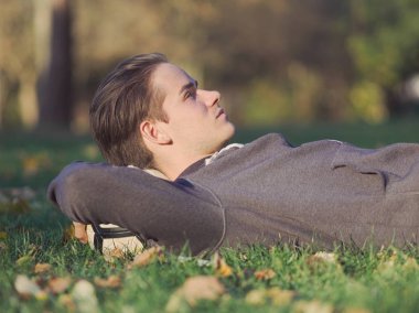 Parkta futbol ile çim güneşli bir sonbahar gününde yalan futbolcu