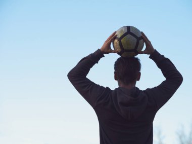 Futbol karşı açık mavi gökyüzü ile poz futbolcu