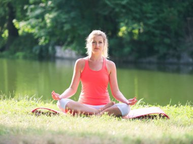 Parkta yoga yapan kadın.