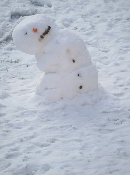 一个正在融化的雪人斜靠在旁边 图库图片