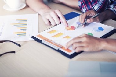 Birlikte çalışma ve mali rakamlar bir grafikler üzerinde analiz iş adamları.