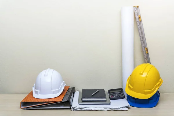 Construction background concept with construction accessories, file, helmet, blueprint, notebook, calculator and level meter on table  at workplace room with free copy space for text.