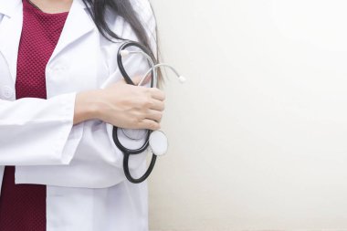 Sağlık arka plan kavramı. Boş alanı olan beyaz duvar stetoskop ayakta tutan Closeup doktor.