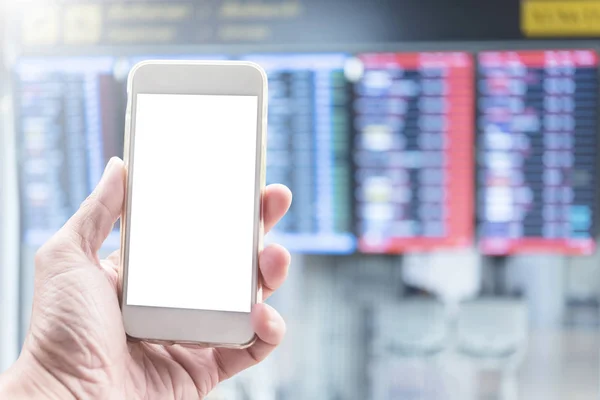 Mockup of mobile with free space. Hand holding mobile in airport with blurred flight board background. Technology and travel concept.