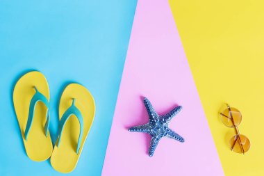 Yaz konsepti. Terlik, güneş gözlüğü ve denizyıldızı düz yatıyordu