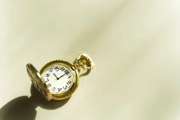 Έννοια του χρόνου. Χρυσό ρολόι τσέπης στο τραπέζι με SUNLI — Φωτογραφία Αρχείου