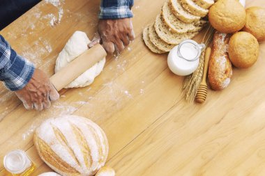 Adam doğa arka plan ile bahçede tepside taze ekmek pişirme.