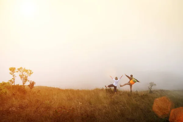 Счастье путешественников, стоящих на горе с восходом или закатом солнца — стоковое фото
