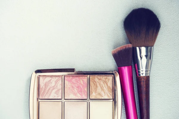 Makeup and beauty concept. Makeup brushes with powder on table.