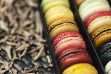 Kutu üzerinde karışık renkli macaroons fre ile doğada yaprakları koymak
