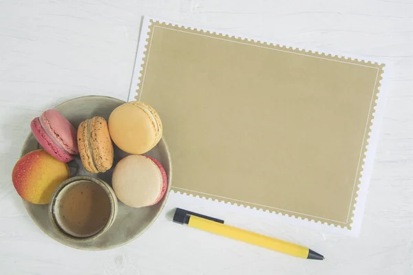 Página vazia de papel marrom e macaroon de sobremesa doce em ba branca Imagem De Stock