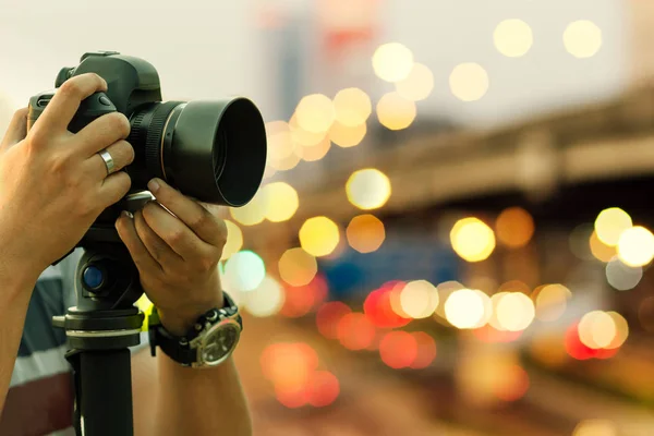 Fotograf schießt im Freien bei Nachtlicht, retro getöntes Bild — Stockfoto