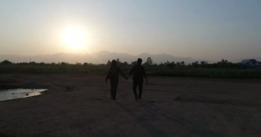 Aşık yürümek el ele akşam mutlu. Gün batımı gün gün sevgi ile iki kişi aşkın.