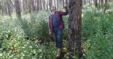 Sırt çantası ile tropikal ormanda yürüyüş genç adam. Orman yolu yürüyüş sırt çantası ile erkek fiyatı.