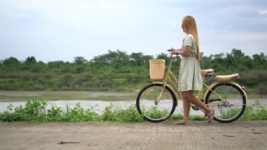 Bisiklet park üzerinde yürüme ile genç kadın