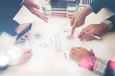 Girişimci iş adamları grup toplantısı. İnsanlar konferansta birlikte oturup notlar alıyorlar. Toplantıda iş belgesine işaret eden eller.