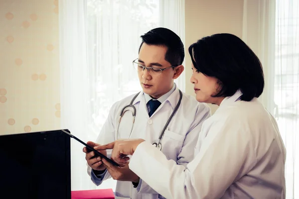 Dos Doctores Discuten Trabajo Mientras Miran Través Tableta Juntos Hospital —  Fotos de Stock