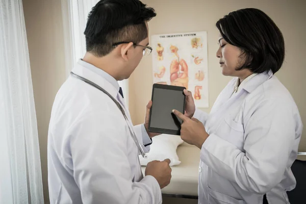 Dos Doctores Discuten Trabajo Mientras Miran Través Tableta Juntos Hospital —  Fotos de Stock