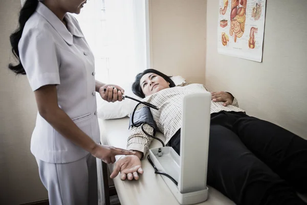 입원중에 혈압을 측정하고 환자들을 간호하는 간호사의 — 스톡 사진