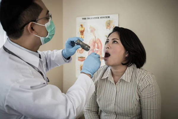 Beyaz Üniformalı Bir Doktor Fenerli Bir Hastanın Ağzını Kontrol Ediyor — Stok fotoğraf