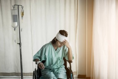 Tekerlekli sandalyede oturan kadın hastalar hastaneye kaldırıldıktan sonra acı çekiyor.