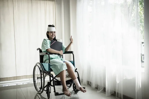 車椅子に座っている女性患者は彼女の手に文書を持っている 怪我と治癒の概念 — ストック写真