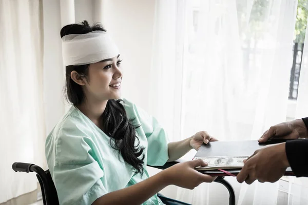 Paciente Sentada Una Enfermera Silla Ruedas Entregando Sus Documentos Mano —  Fotos de Stock