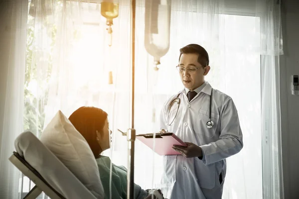 Doctor Escribiendo Portapapeles Mientras Mira Paciente Hospital —  Fotos de Stock