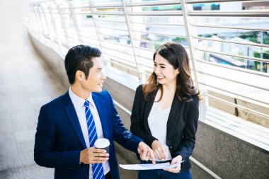 İş arkadaşları birlikte ofise yürürken tabletteki işlere bakarlar..