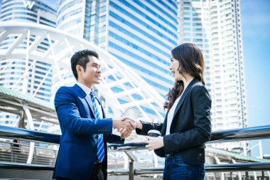 İş ortağı tabletteki başarılı işlere bakarken el sıkışıyor. İş konsepti.